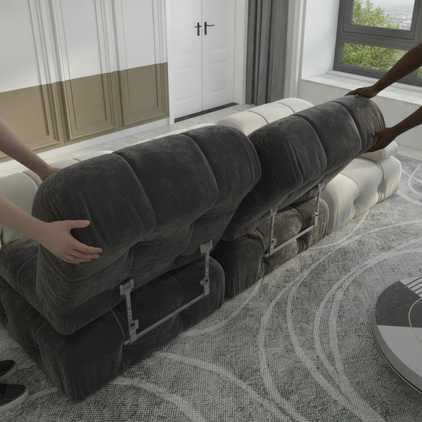 Two hands, one light-skinned and one dark-skinned, separate modules of a charcoal velvet sectional sofa, showing the interloc