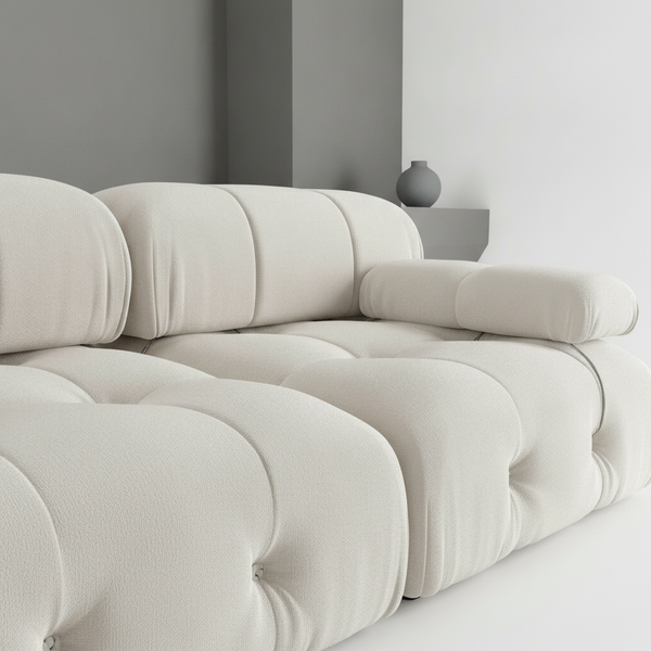 Close-up of a minimalist velvet modular sectional sofa, showing the luxurious texture of the dark gray velvet fabric, highlig
